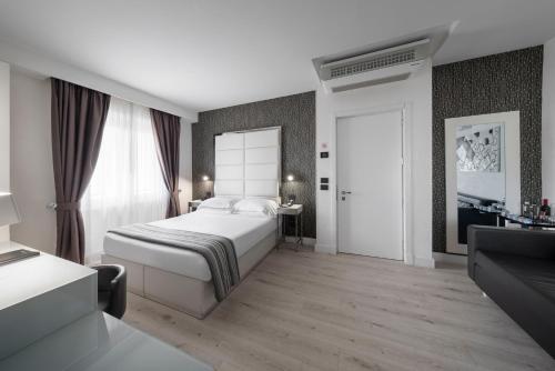 a bedroom with a white bed and a bathroom at LHP Hotel River & SPA in Florence