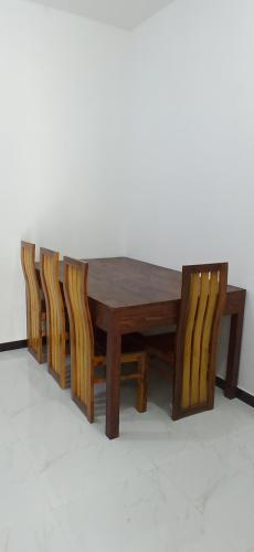a wooden table with four chairs around it at Sandakini Home Rest in Ahangama