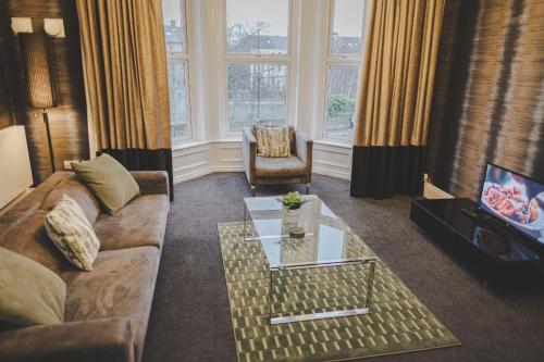a living room with a couch and a coffee table at Kensington House by Warren Collection in Newcastle upon Tyne