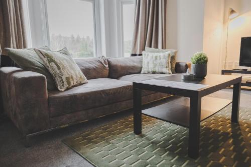 a living room with a couch and a coffee table at Kensington House by Warren Collection in Newcastle upon Tyne