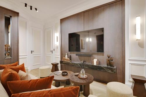 un salon avec un canapé et une télévision sur un mur dans l'établissement TheLander - Serviced Apartments in Saint Germain des Prés, à Paris