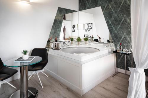 a bathroom with a large tub and a table at LHP Hotel River & SPA in Florence