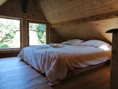 a bedroom with a bed in a log cabin at Cabanon in Sapois