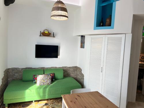 a living room with a green couch and a table at Pompei Sunday Estate Exclusive Apartaments in Pompei