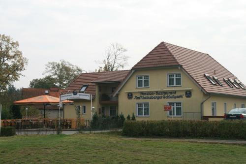 a large yellow building with a roof at Pension Am Rheinsberger Schloßpark in Rheinsberg