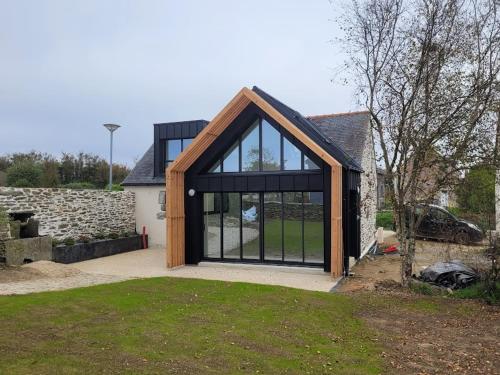 an extension to a house with a large glass door at La grange de Rose et François in Le Conquet
