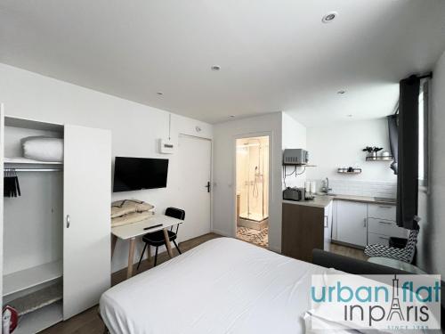 une chambre avec un lit et un bureau et une cuisine dans l'établissement 183 - Villette Studio, à Paris