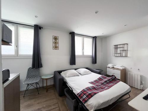 une chambre avec un lit, une table et des fenêtres dans l'établissement 183 - Villette Studio, à Paris