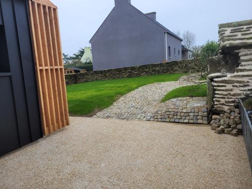 an open door to a yard with a stone wall at La grange de Rose et François in Le Conquet