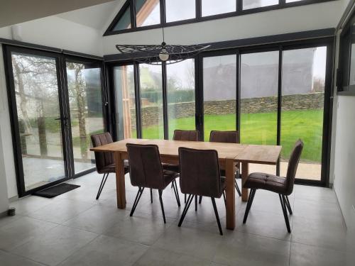 a dining room with a wooden table and chairs at La grange de Rose et François in Le Conquet