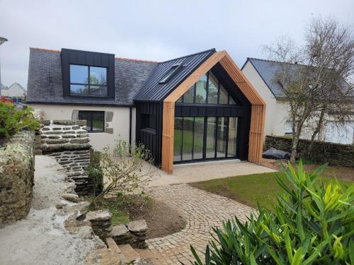 a house with a gambrel roof and a stone walkway at La grange de Rose et François in Le Conquet