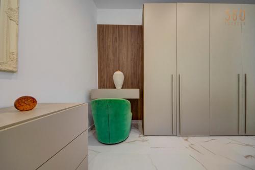 a kitchen with a green stool next to a refrigerator at Modern apartment with spacious terrace in Attard by 360 Estates in Attard