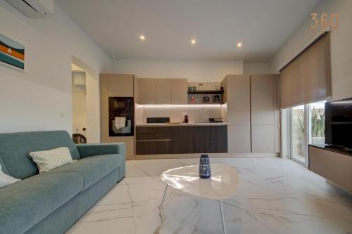 a living room with a blue couch and a table at Modern apartment with spacious terrace in Attard by 360 Estates in Attard