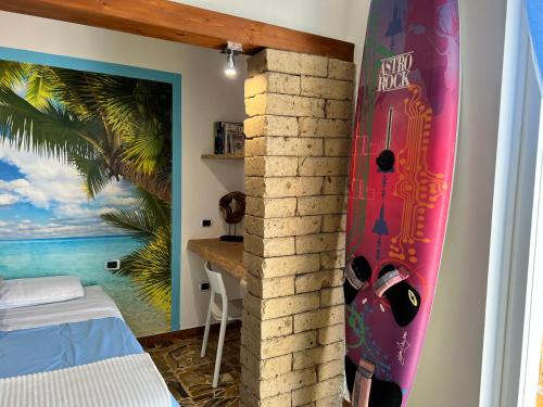 a surfboard leaning against a wall in a room at Pompei Sunday Estate Exclusive Apartaments in Pompei