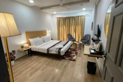 a hotel room with a bed and a television at Saltstayz Sector 39- Near Rajiv Chowk & Sohna Road in Gurgaon