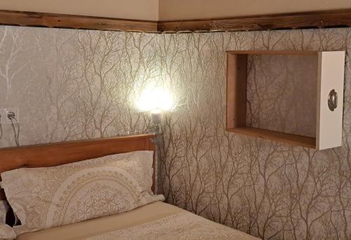 a bedroom with a bed and a light on a wall at Naturetouch in Steinberg am Rofan