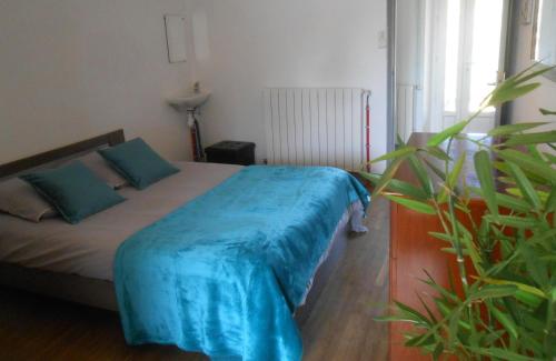 a bedroom with a bed with a blue blanket on it at Gite lili in Blis-et-Born