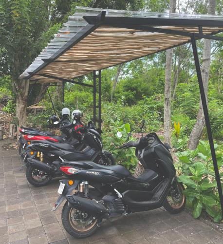 a group of motorcycles parked under a wooden structure at Tropical Almond Villa in Uluwatu