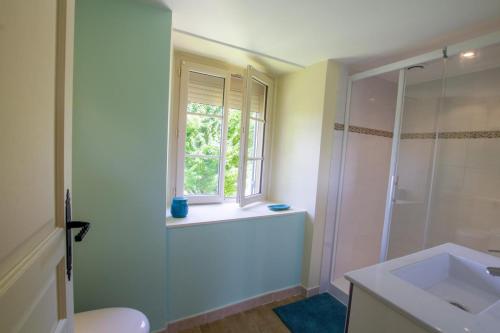 une salle de bain avec une douche et un lavabo et une fenêtre dans l'établissement La maison de mamie, à Allemans