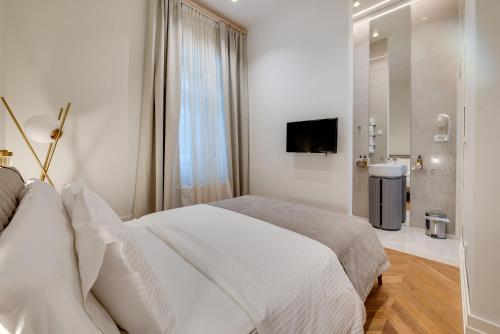 a white bedroom with a large bed and a bathroom at Villa Ariston in Opatija