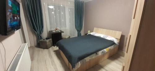 a small bedroom with a bed and a television at Studio Ultracentral cu balcon in Onești