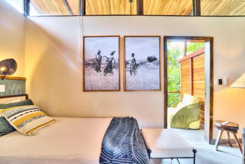 a bedroom with a bed and two windows at Conga Boutique Hotel in Puerto Viejo