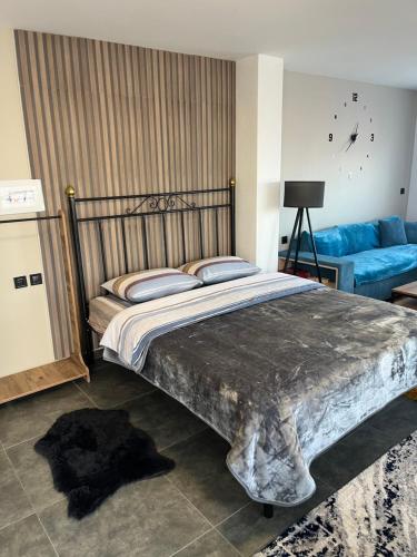 a bedroom with a large bed and a blue couch at ElatoVillage in Elatochori