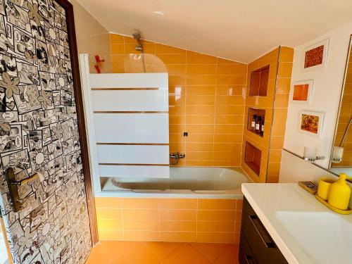 an orange bathroom with a tub and a sink at Fil Rouge in Ciampino