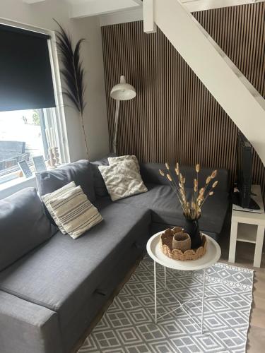a living room with a blue couch and a table at Vakantiehuis Katwijk Andreasplein in Katwijk
