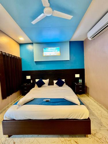 a bedroom with a large bed with a blue wall at Golden Pearl Resort By Gemstone Hospitality in Alibag