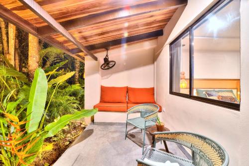 an outdoor patio with two chairs and a bench at Conga Boutique Hotel in Puerto Viejo