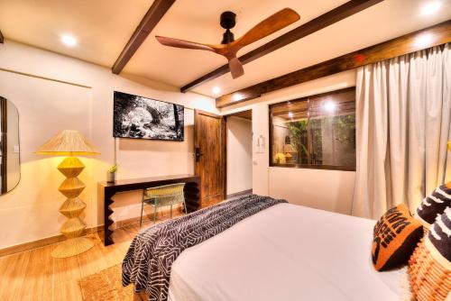a bedroom with a bed and a ceiling fan at Conga Boutique Hotel in Puerto Viejo