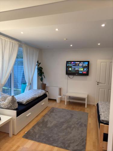 a bedroom with a bed and a tv on the wall at Gemütliches Gasthaus in Pinneberg
