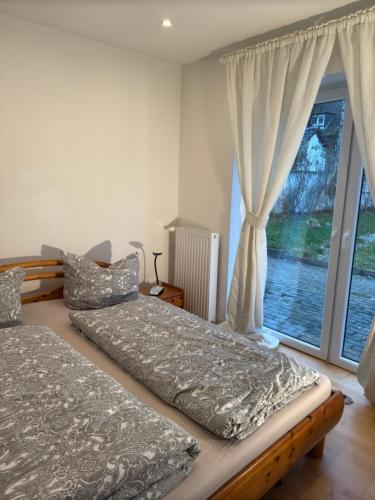 a bedroom with two beds and a large window at Gemütliches Gasthaus in Pinneberg