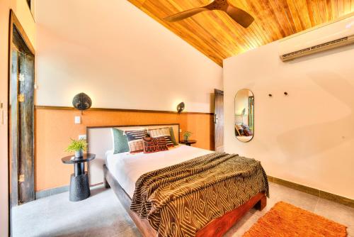a bedroom with a bed and a wooden ceiling at Conga Boutique Hotel in Puerto Viejo