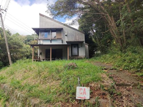 a house sitting on top of a grassy hill at 南伊豆ランドホピア Minami Izu Land Hopia in Minamiizu