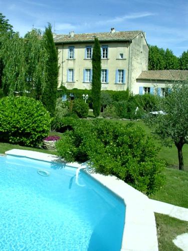 une grande piscine bleue devant un immeuble dans l'établissement Maison Sule, à Malaucène