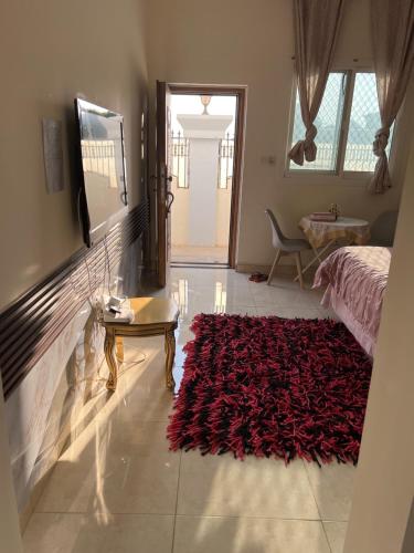 a bedroom with a bed and a red rug at Alhosani property in Abu Dhabi