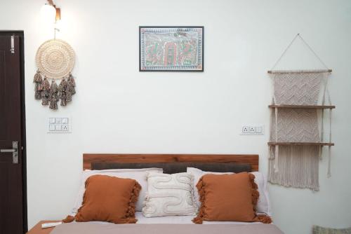 a bedroom with a bed with pillows and a clock on the wall at Mild Life Hostel Rishikesh in Rishīkesh