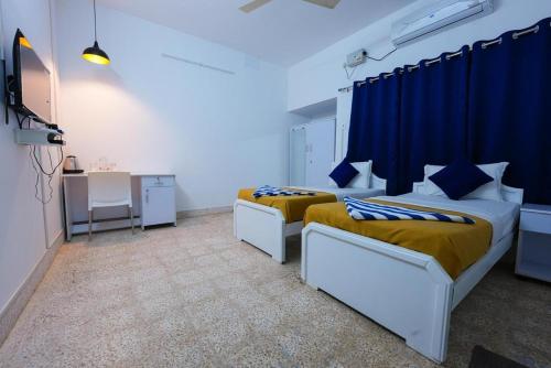 Ένα ή περισσότερα κρεβάτια σε δωμάτιο στο Madras Inn Nungambakam