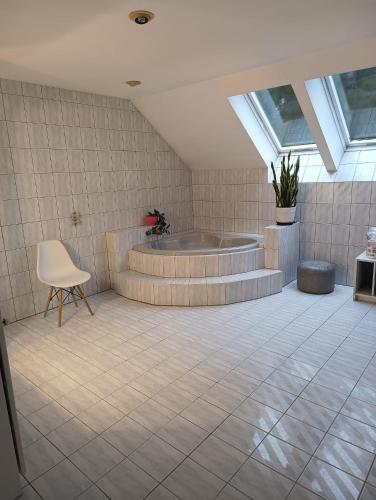 a bathroom with a tub and a chair in it at Dom blisko lotniska i Areny Tarczyńskiego in Wrocław