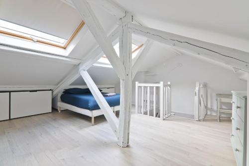 Cette chambre mansardée comprend un lit bleu. dans l'établissement Superb Appartement Quartier Tour Eiffel 8 Free Netflix, à Paris