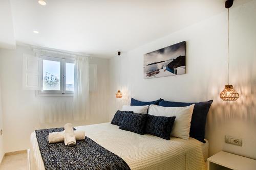 a bedroom with a bed and two lights and a window at Santorini Villatzio Suites in Mesaria