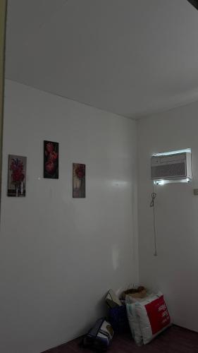 a room with a white wall with a heater and pictures at Reymen's Transient in San Fernando