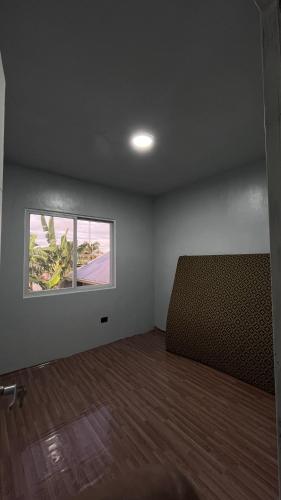 an empty room with a couch and a window at Reymen's Transient in San Fernando