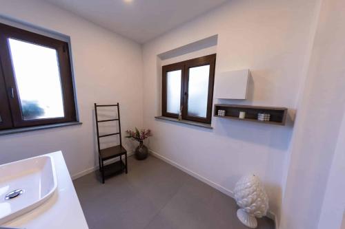 a bathroom with a sink and two windows at River Hotel in Castel di Sangro
