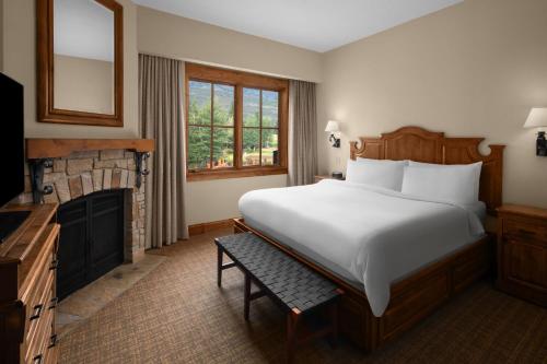 a bedroom with a large white bed and a fireplace at Hotel Park City, Autograph Collection in Park City