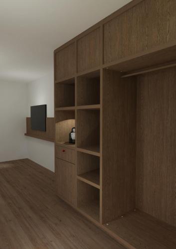 a wooden book shelf with a tv in a room at Bryggjan Boutique Hotel in Akureyri