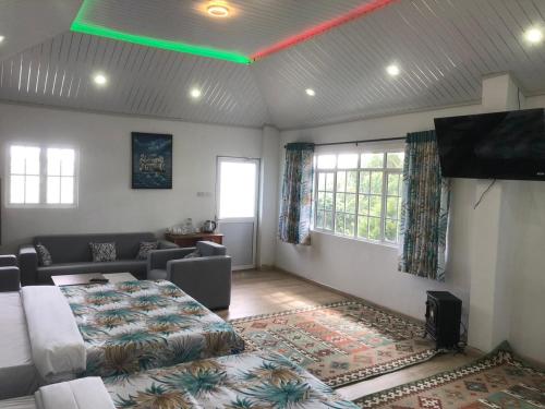 a living room with a bed and a flat screen tv at Panorama Green View Hotel Nuwara Eliya in Nuwara Eliya