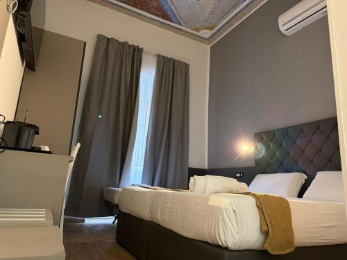 a bedroom with two beds and a large window at Conte GuestHouse in Rome